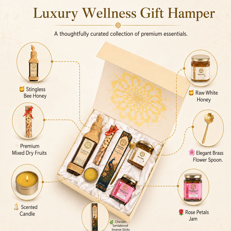 Luxury Wellness Gift Hamper featuring a curated collection of premium wellness items including Stingless Bee Honey, Raw White Honey, Premium Mixed Dry Fruits, a Scented Candle, Rose Petals Jam, and an Elegant Brass Flower Spoon, arranged inside an open beige gift box with gold detailing.
