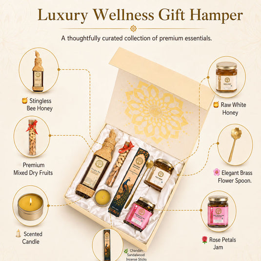 Luxury Wellness Gift Hamper featuring a curated collection of premium wellness items including Stingless Bee Honey, Raw White Honey, Premium Mixed Dry Fruits, a Scented Candle, Rose Petals Jam, and an Elegant Brass Flower Spoon, arranged inside an open beige gift box with gold detailing.