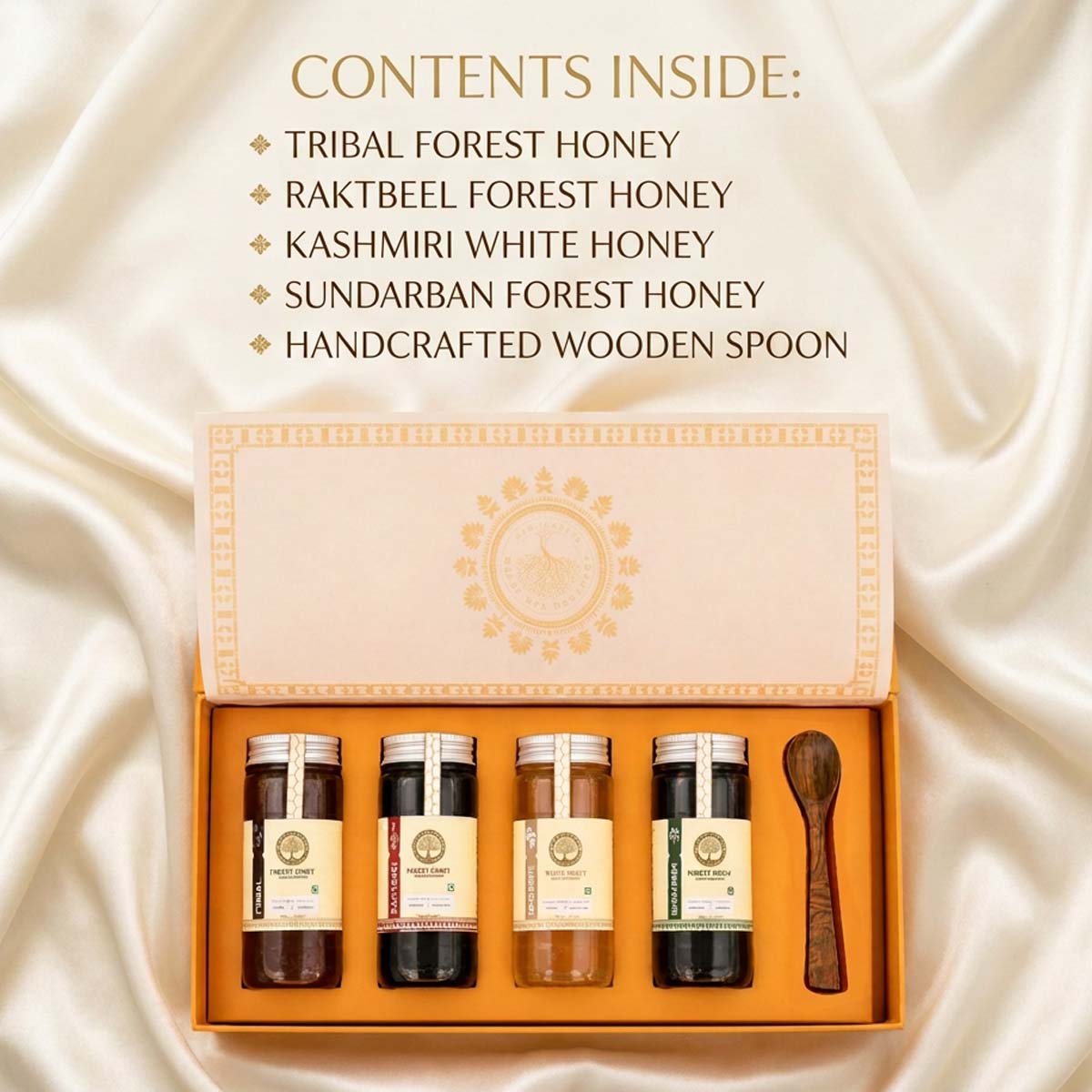 An open gift box of four honey jars and a wooden spoon on a cream satin background, with text listing contents: tribal forest honey, rakteel forest honey, Kashmiri white honey, sundarban forest honey, and a handcrafted wooden spoon.
